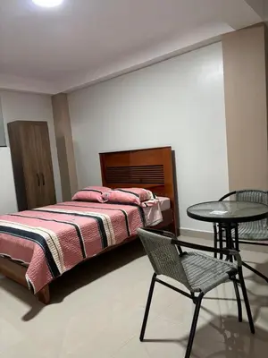 a bedroom with a bed and a table and a chair at Hotel Roma Quillabamba in Quillabamba