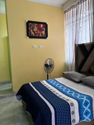 a bedroom with a bed with a blue and white blanket at Hotel Roma Quillabamba in Quillabamba
