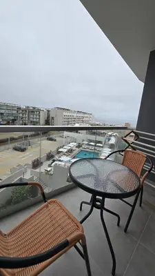 a table and chairs on a balcony with a view of a parking lot at Exclusive apartment in San Bartolo in San Bartolo