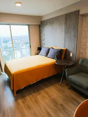 a bedroom with a large bed and a chair at JAVIER PRADO ESTE 1501 LOFT- FRENTE a SAN BORJA in Lima