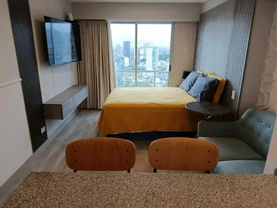 a hotel room with a bed and a couch and a window at JAVIER PRADO ESTE 1501 LOFT- FRENTE a SAN BORJA in Lima