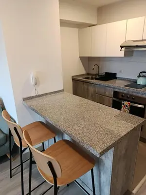 a kitchen with a granite counter top and chairs at JAVIER PRADO ESTE 1501 LOFT- FRENTE a SAN BORJA in Lima