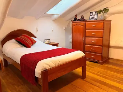 a bedroom with a large bed and a dresser at Andes Home in Cusco