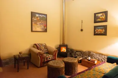 a living room with a couch and a fire place at Cabin in Inca Sanctuary in Ollantaytambo