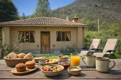 a wooden table with breakfast foods and orange juice at Cabin in Inca Sanctuary in Ollantaytambo
