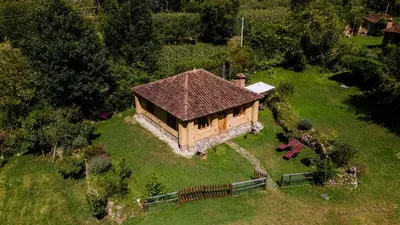 a small house with a roof on a green field at Cabin in Inca Sanctuary in Ollantaytambo