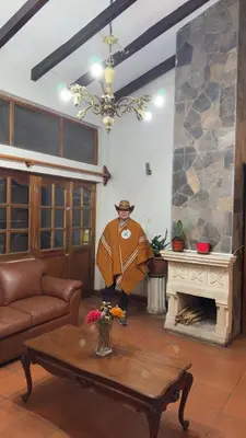 a man standing in a living room with a fireplace at Apartamento Plaza de armas de Ayacucho in Ayacucho