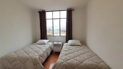 two beds in a room with a window at Modern Apartament Pool & Jacuzzi 1 room in Lima
