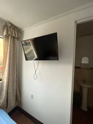 a flat screen tv on the wall of a bedroom at HOSPEDAJE VISTA DEL SOl PARACAS in Paracas