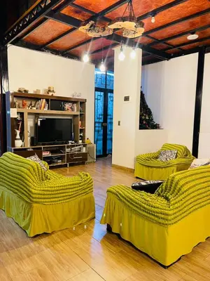 a living room with two beds and a flat screen tv at Casa La Morada Ecolodge in Ayacucho