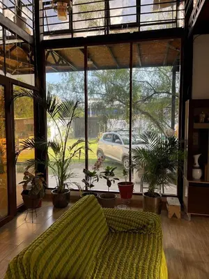 a living room with a bed and potted plants at Casa La Morada Ecolodge in Ayacucho
