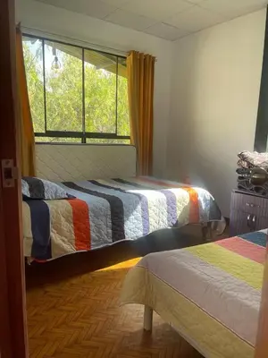 a bedroom with two beds and a window at Casa La Morada Ecolodge in Ayacucho