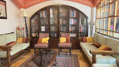 a living room with two couches and book shelves at Casa Elena in Cusco
