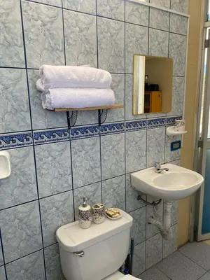 a bathroom with a toilet and a sink and towels at Central 3 minutes from Plaza de Armas by car in Quillabamba