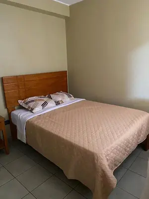a bedroom with a bed with a wooden headboard at Central 3 minutes from Plaza de Armas by car in Quillabamba