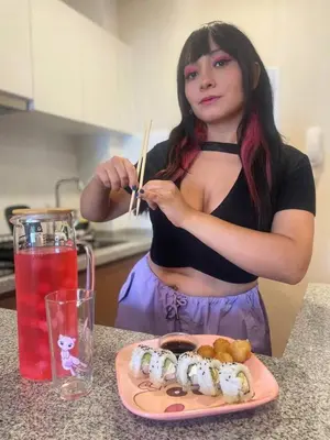 a woman holding a pair of chopsticks next to a plate of sushi at Anime-Style Studio Decor in Lima