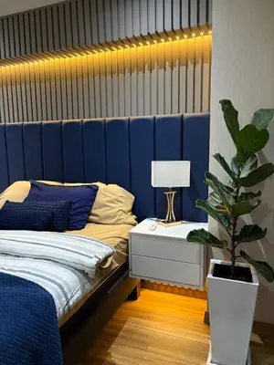 a blue bedroom with a bed and a potted plant at Salaverry Luxury Apartment in Lima