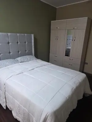 a bedroom with a large white bed and a dresser at room rent in Lima