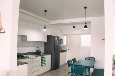 a kitchen with a table and a black refrigerator at Increible casa de playa con vista al lago in San Vicente de Cañete