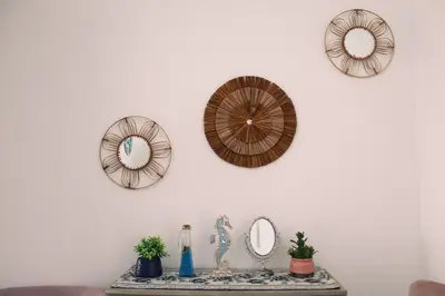 a table with three mirrors on a white wall at Increible casa de playa con vista al lago in San Vicente de Cañete