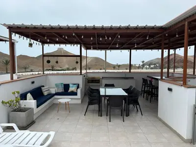 a patio with a table and chairs on a roof at Increible casa de playa con vista al lago in San Vicente de Cañete