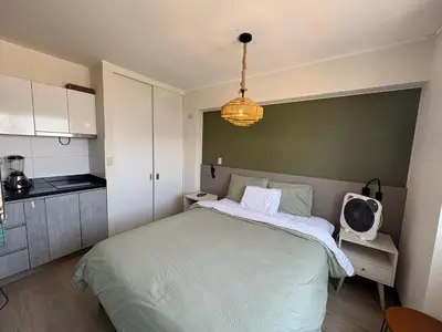 a bedroom with a large bed and a kitchen at Departamento en barranco in Lima
