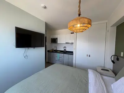 a bedroom with a bed and a television and a chandelier at Departamento en barranco in Lima