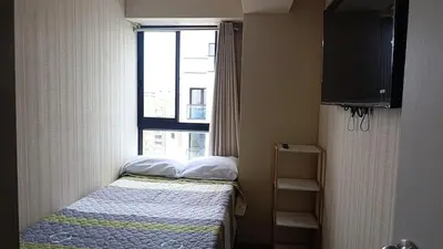 a small bed in a small room with a window at Amplio Dpto Centrico frente al Hospital Rebagliati in Lima