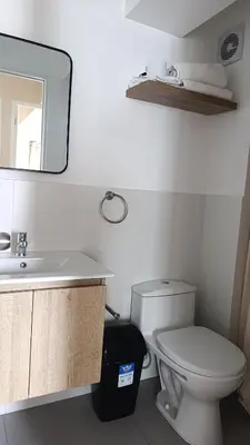 a bathroom with a toilet and a sink and a mirror at Amplio Dpto Centrico frente al Hospital Rebagliati in Lima