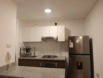 a kitchen with a stainless steel refrigerator and white cabinets at Amplio Dpto Centrico frente al Hospital Rebagliati in Lima