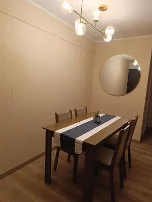 a dining room table with chairs and a mirror at Amplio Dpto Centrico frente al Hospital Rebagliati in Lima