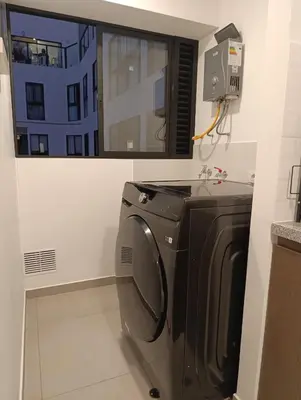 a kitchen with a washing machine and a window at Amplio Dpto Centrico frente al Hospital Rebagliati in Lima
