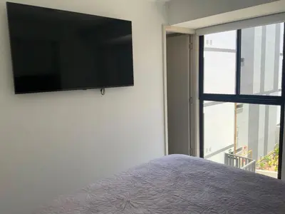 a bedroom with a flat screen tv on a wall at Modern apartment in Larco 791 in Lima