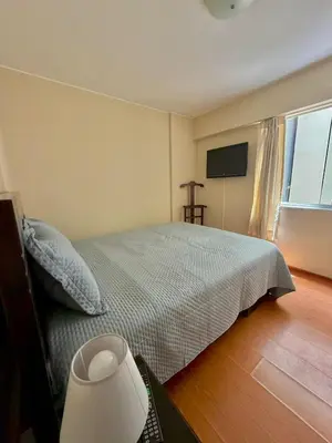 a bedroom with a bed and a large window at Casa de Liz in Lima