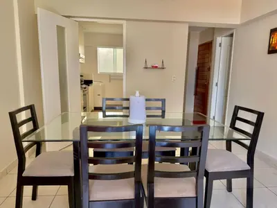 a glass dining room table with chairs and a candle on it at Casa de Liz in Lima