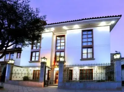 a white building with a fence in front of it at Xima Cusco Kenamari in Cusco
