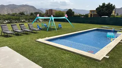 a pool in a yard with chairs and a swing at House 3M in Condominium Fundo Pradera, Chocaya - Lima - Perú in Asia
