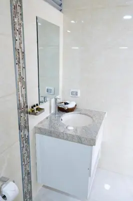 a white bathroom with a sink and a mirror at Solay Inn in Ayacucho