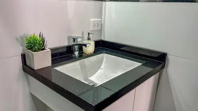 a bathroom sink with a black counter top at Departamento Illapa in Cusco