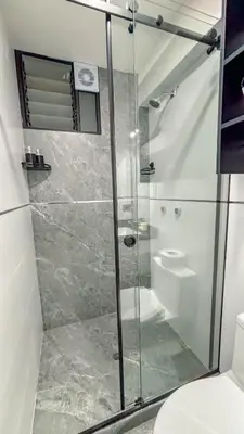 a bathroom with a glass shower with a toilet at Departamento Illapa in Cusco