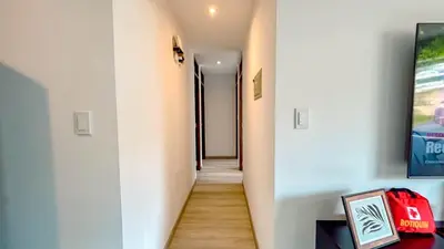 a hallway with white walls and wooden floors at Departamento Illapa in Cusco