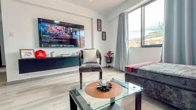 a living room with a couch and a tv at Departamento Illapa in Cusco