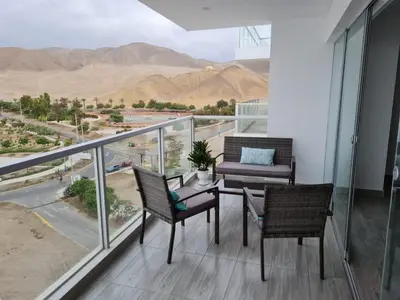a balcony with a table and chairs and a view of the desert at Duplex - Playa Embajadores in Quebrada Seca