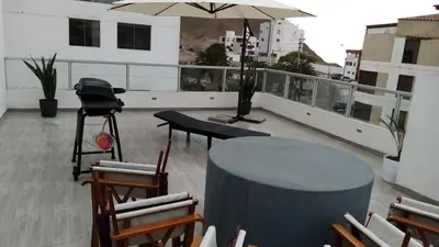 a table and chairs on a balcony with an umbrella at Duplex - Playa Embajadores in Quebrada Seca