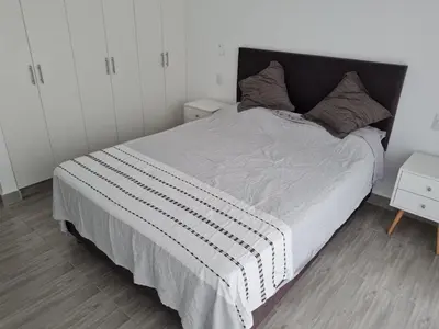 a bedroom with a large bed with a black headboard at Duplex - Playa Embajadores in Quebrada Seca