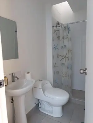 a white bathroom with a toilet and a sink at Vacaciones sin Estres, ambiente relajado y familiar in San Antonio