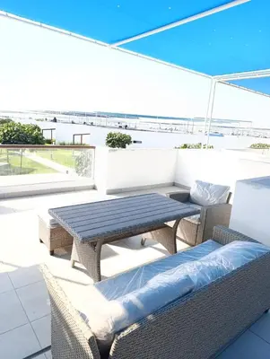 a patio with a table and chairs on a roof at Vacaciones sin Estres, ambiente relajado y familiar in San Antonio
