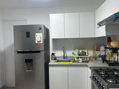 a kitchen with white cabinets and a stainless steel refrigerator at Vacaciones sin Estres, ambiente relajado y familiar in San Antonio