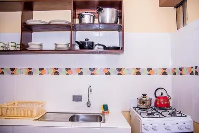 a kitchen with a stove and a sink at Departamentos Santa Ana Barrio Tradicional in Cusco
