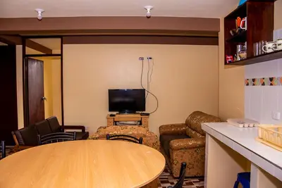 a living room with a table and a tv at Departamentos Santa Ana Barrio Tradicional in Cusco